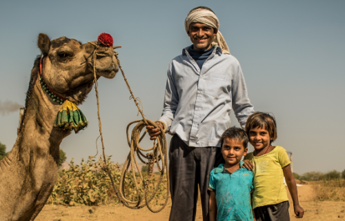 Man and children holding a camel