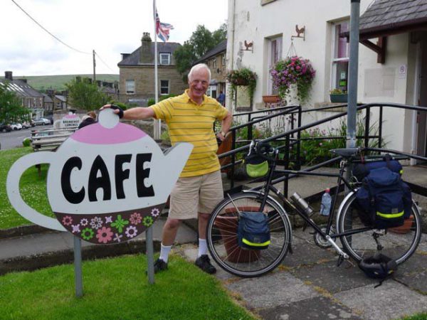 Anthony Smith standing next to cafe sign and bicycle