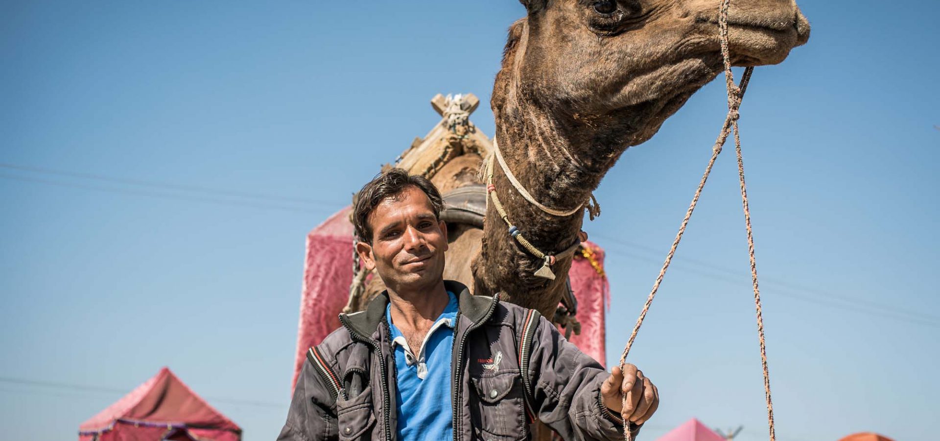 Man standing next to camel