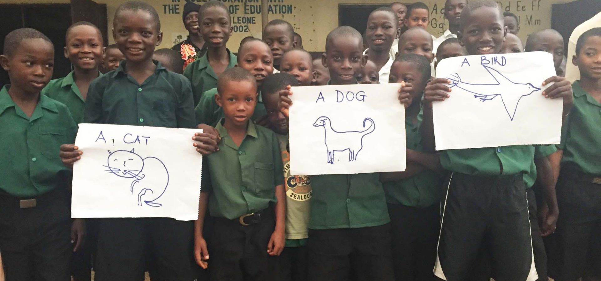 Group of schoolchildren holding drawings of animals