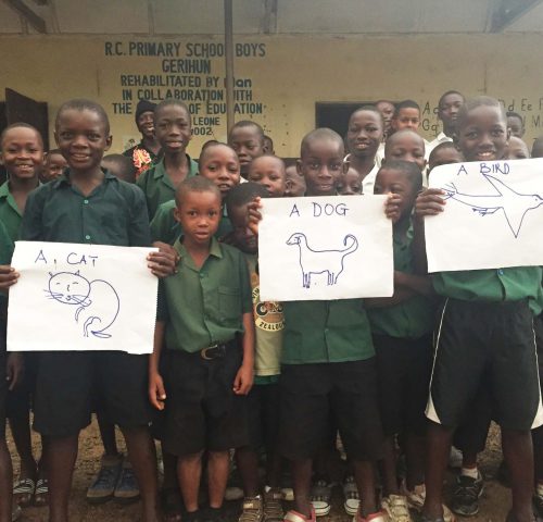 Group of schoolchildren holding drawings of animals