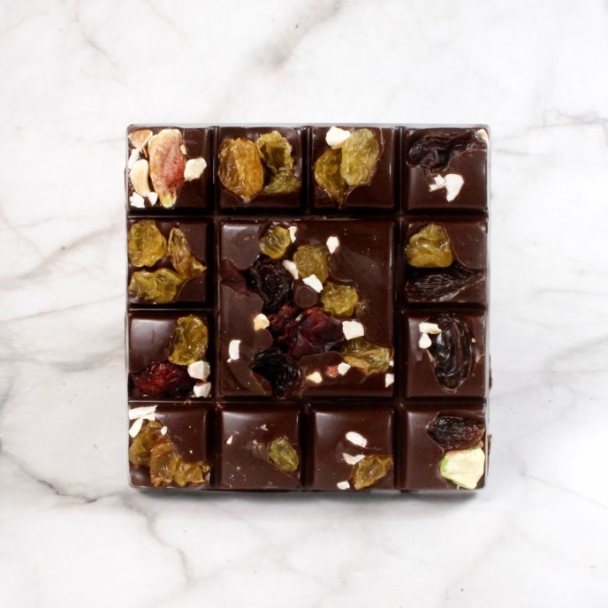 Dark chocolate square with pieces of fruit and nuts