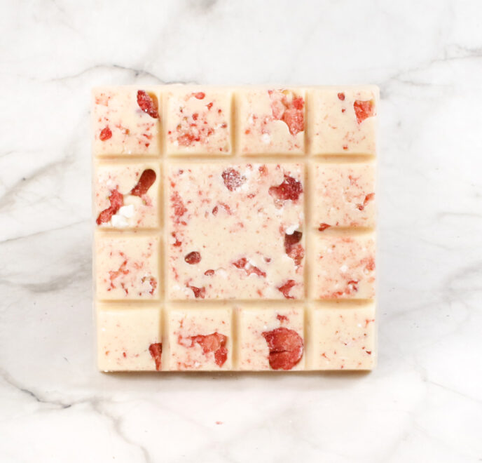 white chocolate square with strawberries and meringue pieces