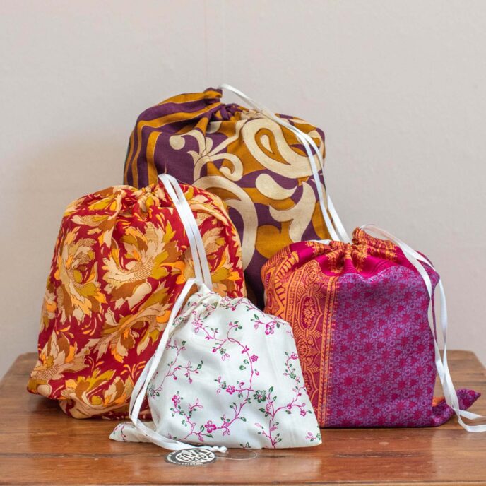 Image of assorted gifts wrapped in multi-coloured recycled sari gift bags