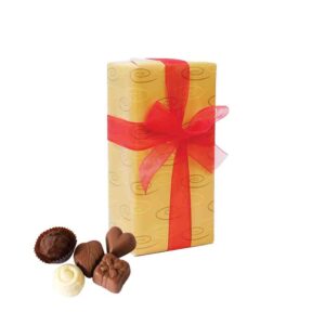 Image of a chocolate box, gift-wrapped in gold paper with a red organza ribbon and loose chocolates