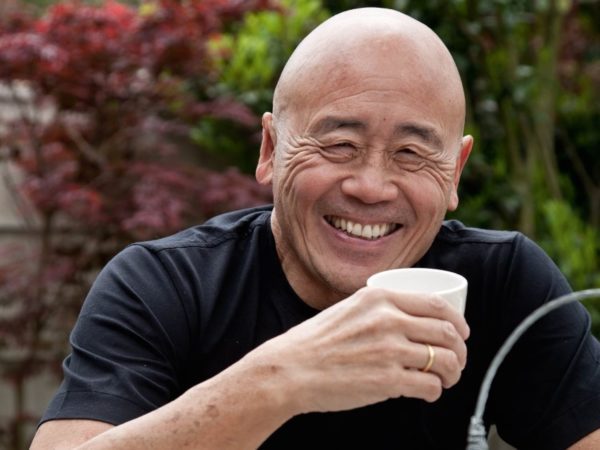 Smiling bald man holding a teacup at the SPANA World Tea Party event