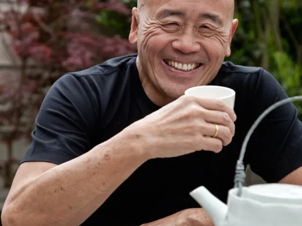 Smiling bald man holding a teacup at the SPANA World Tea Party event