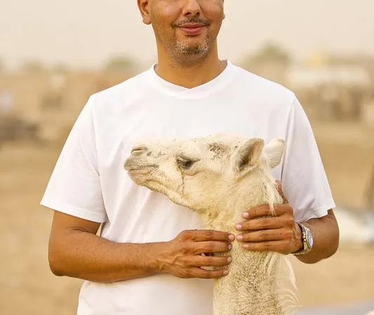 Man and camel calf