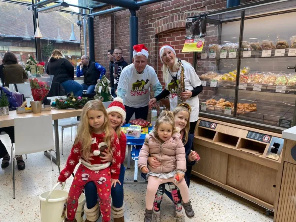 Two adults and three children wearing SPANA outfits smile as they raise funds for working animals in a shop.