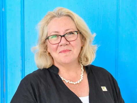 Chief Executive of SPANA Linda Edwards dressed in black shirt against a blue background