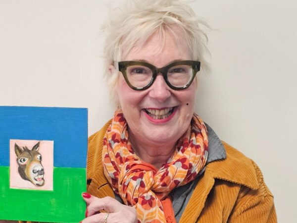 Comedian and actress Jenny Eclair holds her blue and green donkey painting which she is raffling to raise funds for SPANA